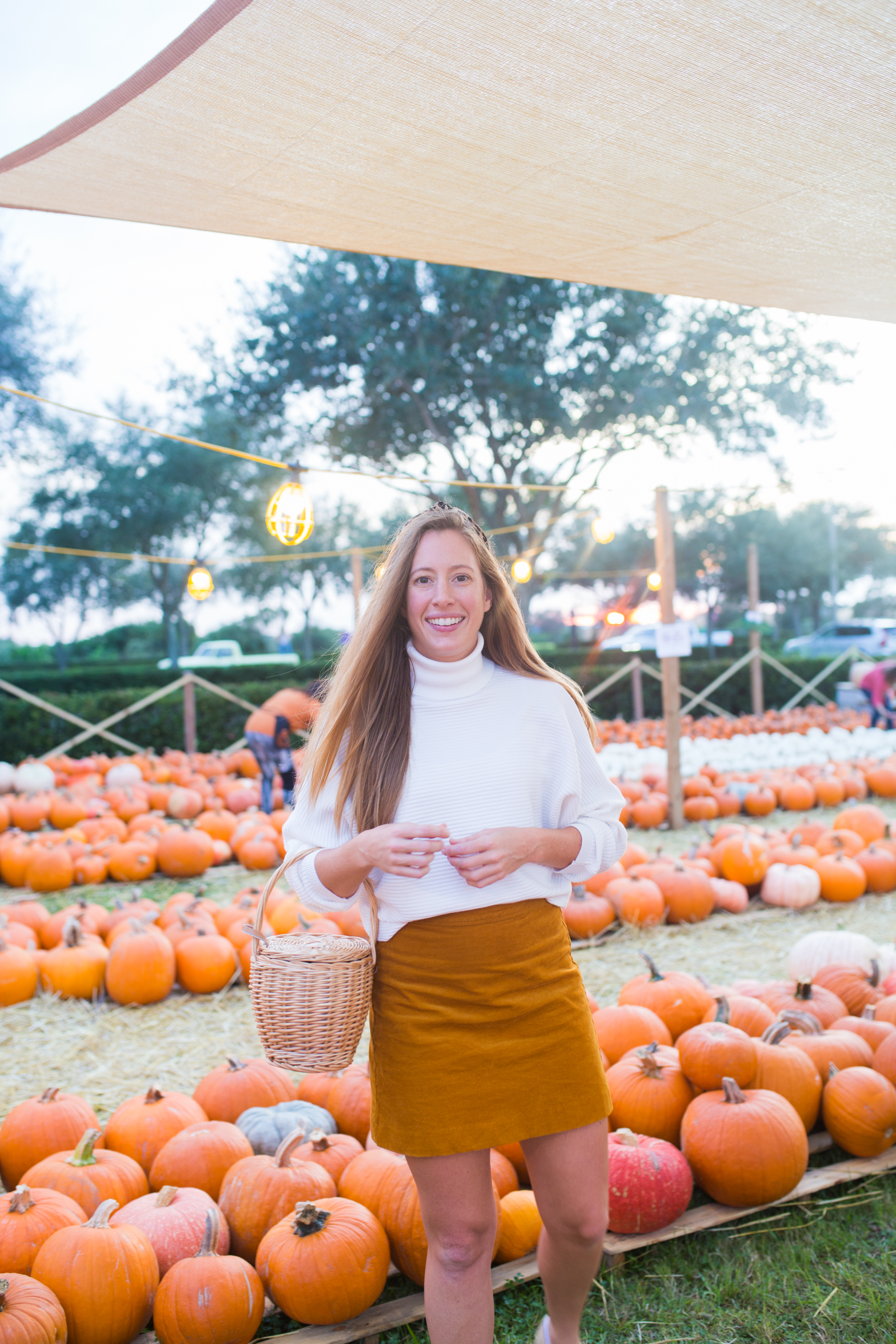 woman in orange skirt and white sweater