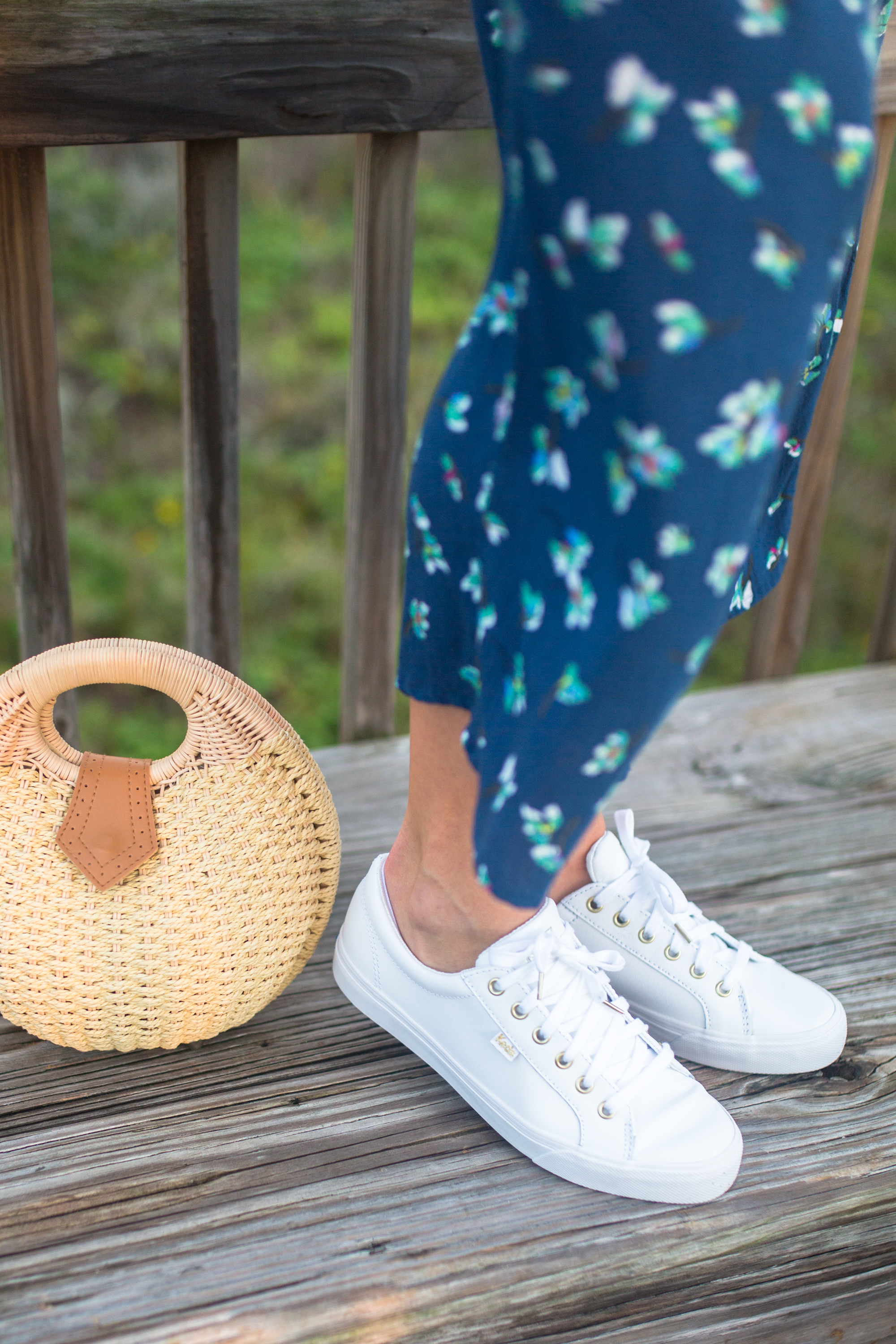 woman in a Tropical Winter Getaway wearing Blue Floral Jumpsuit and white shoes