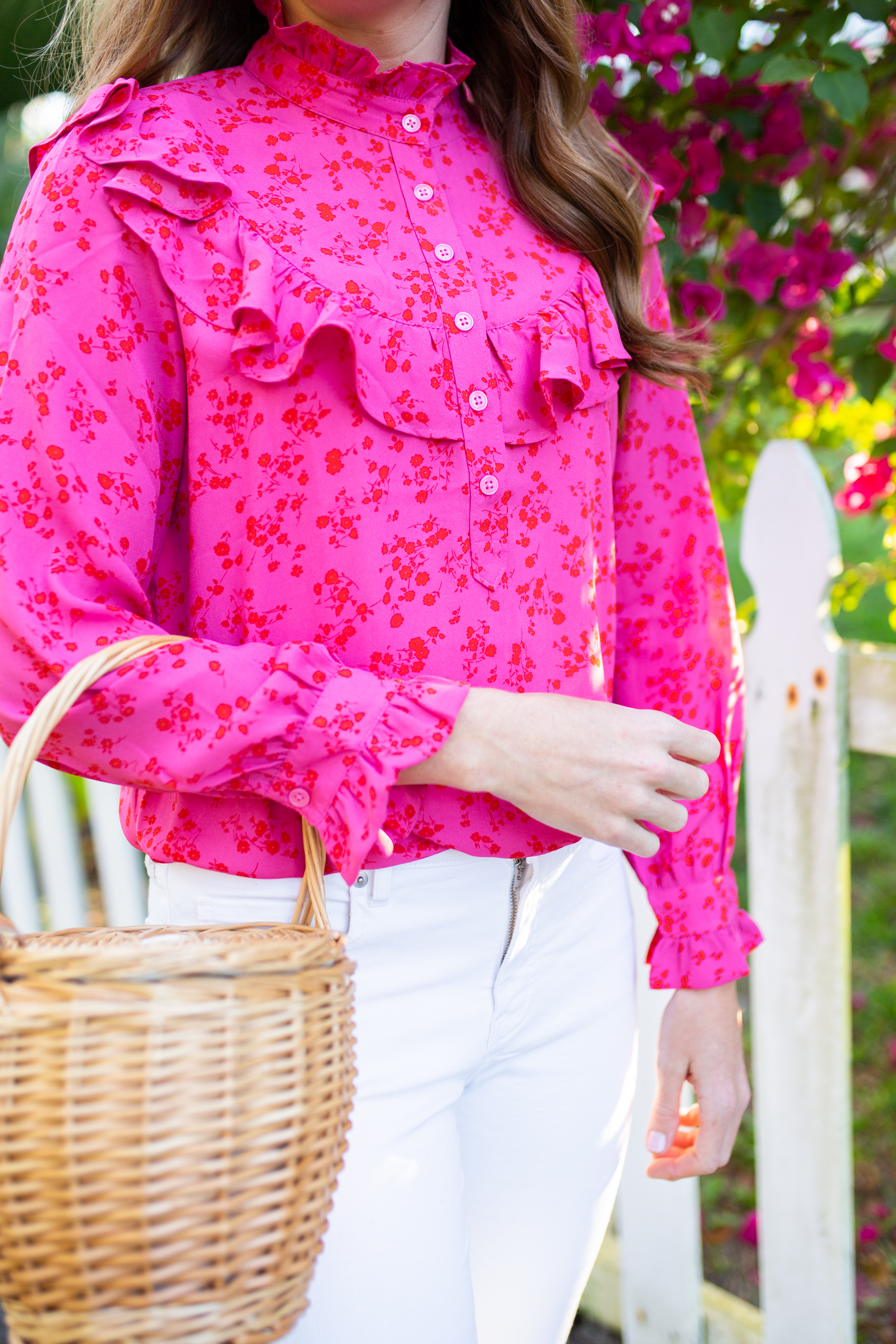 woman wearing Floral Tops for Spring with Ruffle, White Jeans, pink headband, nude flats, and holding a weaved bag