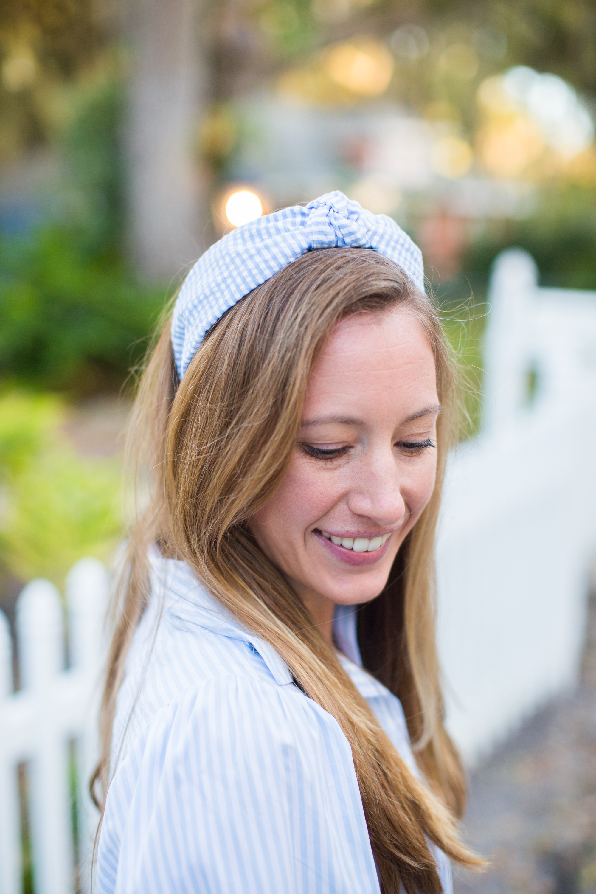 woman walking outside and wearing a Striped Spring Dress, headband, and carrying a bag