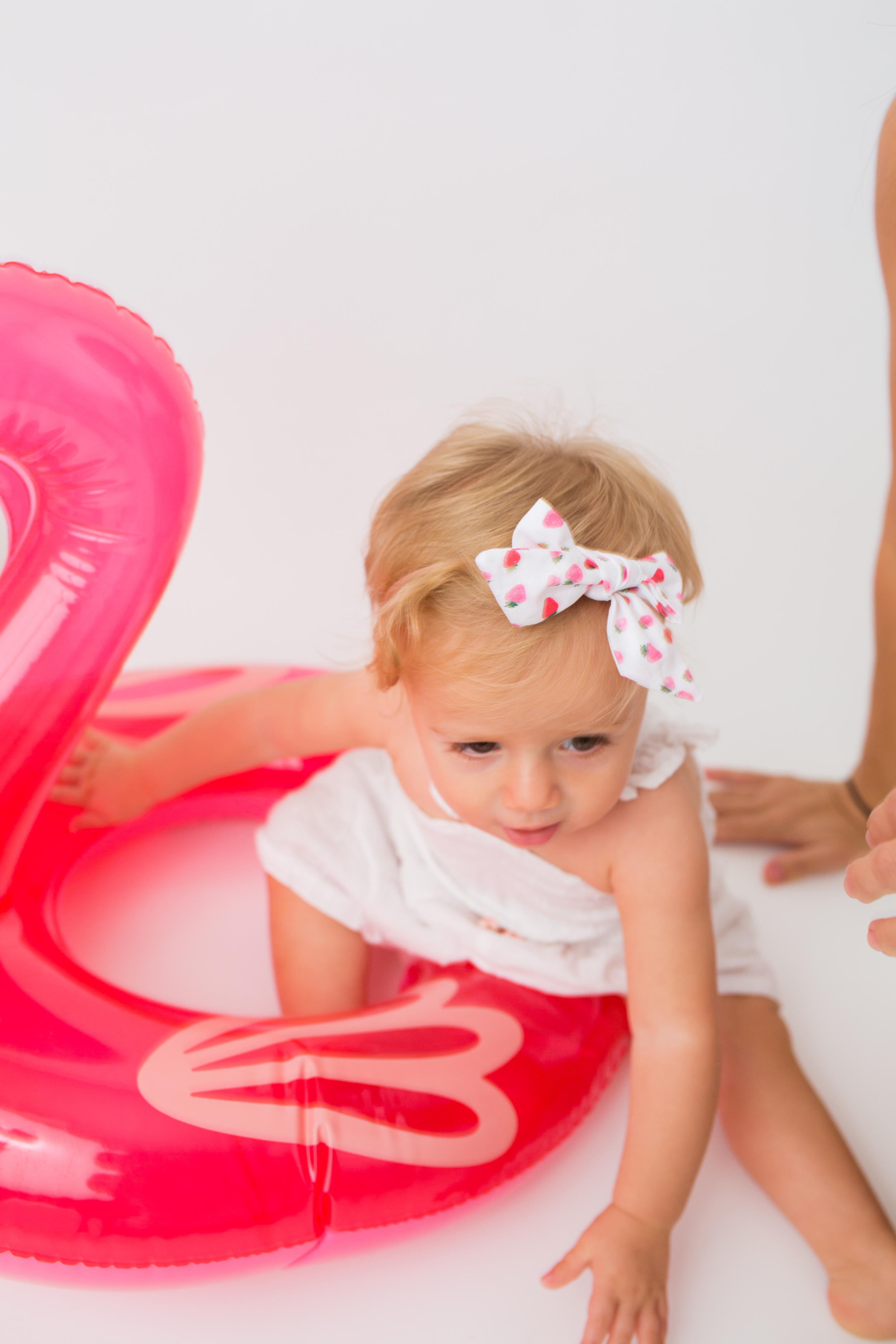 child wearing ribbon and playing with flamingo balloon from Sunshine Style Headbands