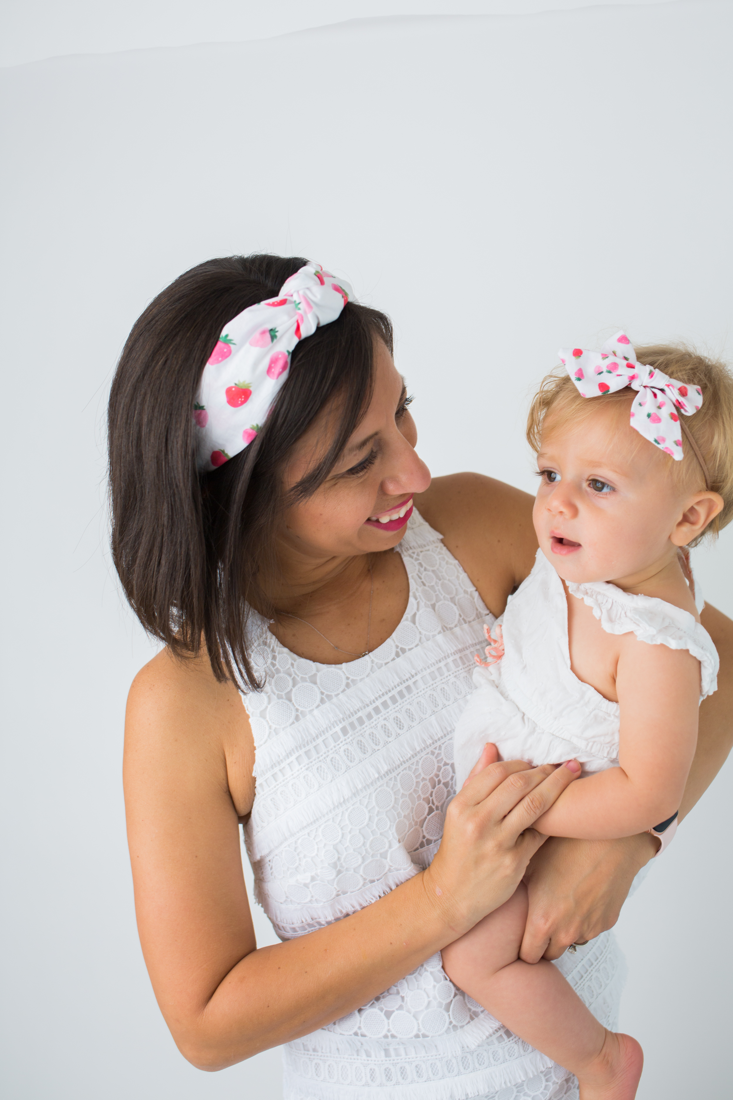 woman carrying her child and wearing Sunshine Style Headbands