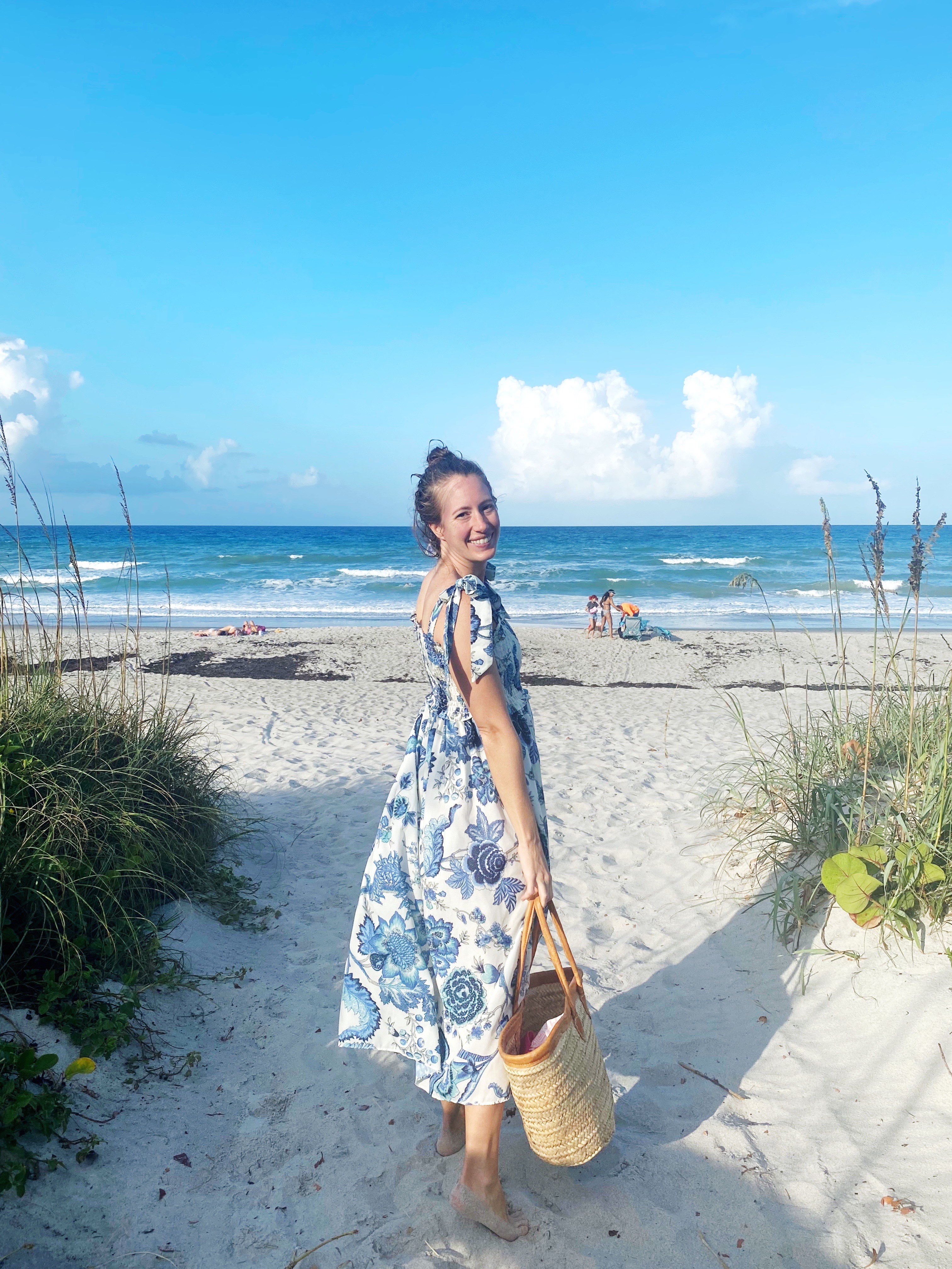 woman smiling and wearing Floral Tie Strap Dress at the beach