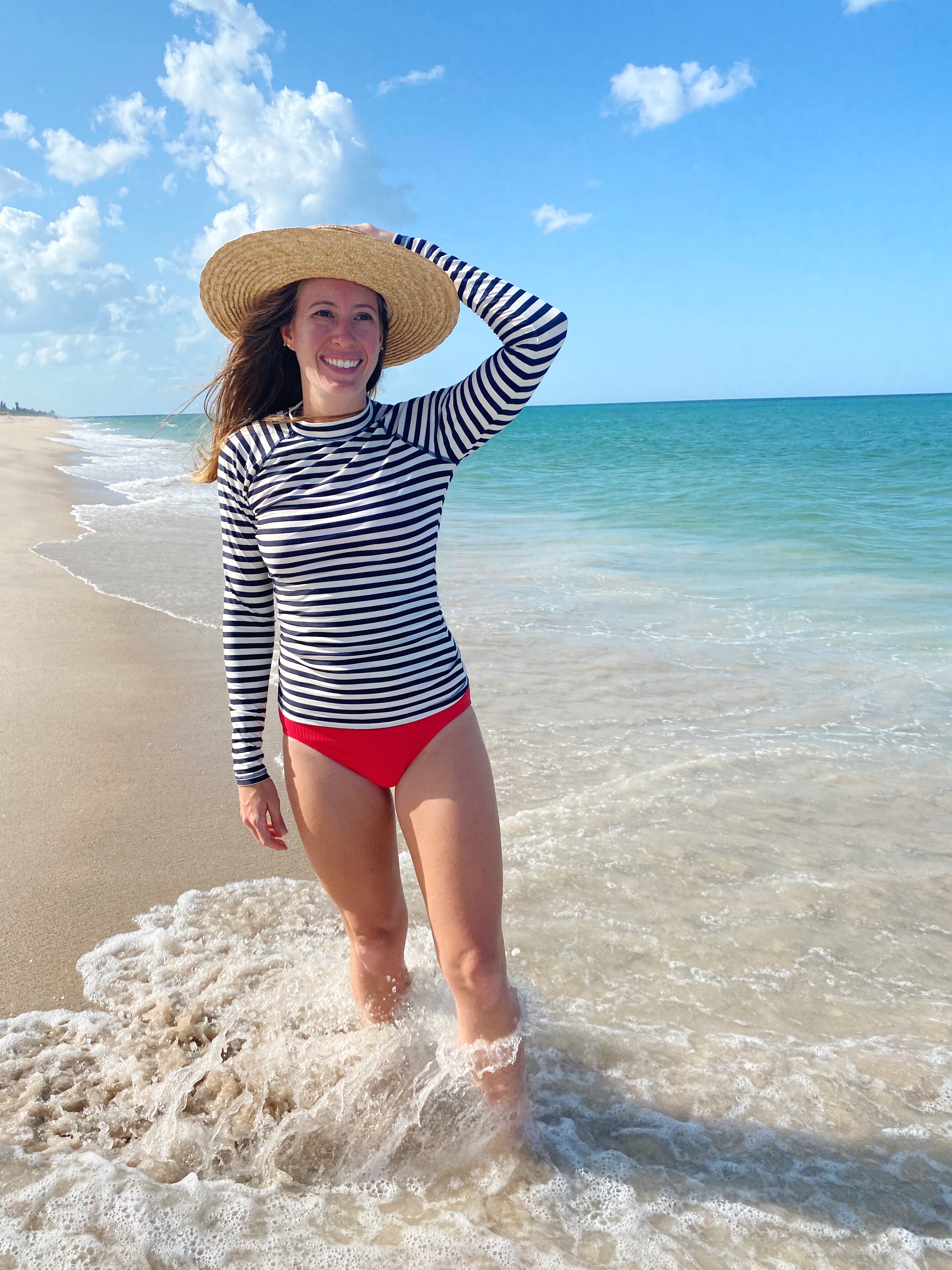 woman wearing Striped Rash Guards  and weaved hat at the beach 