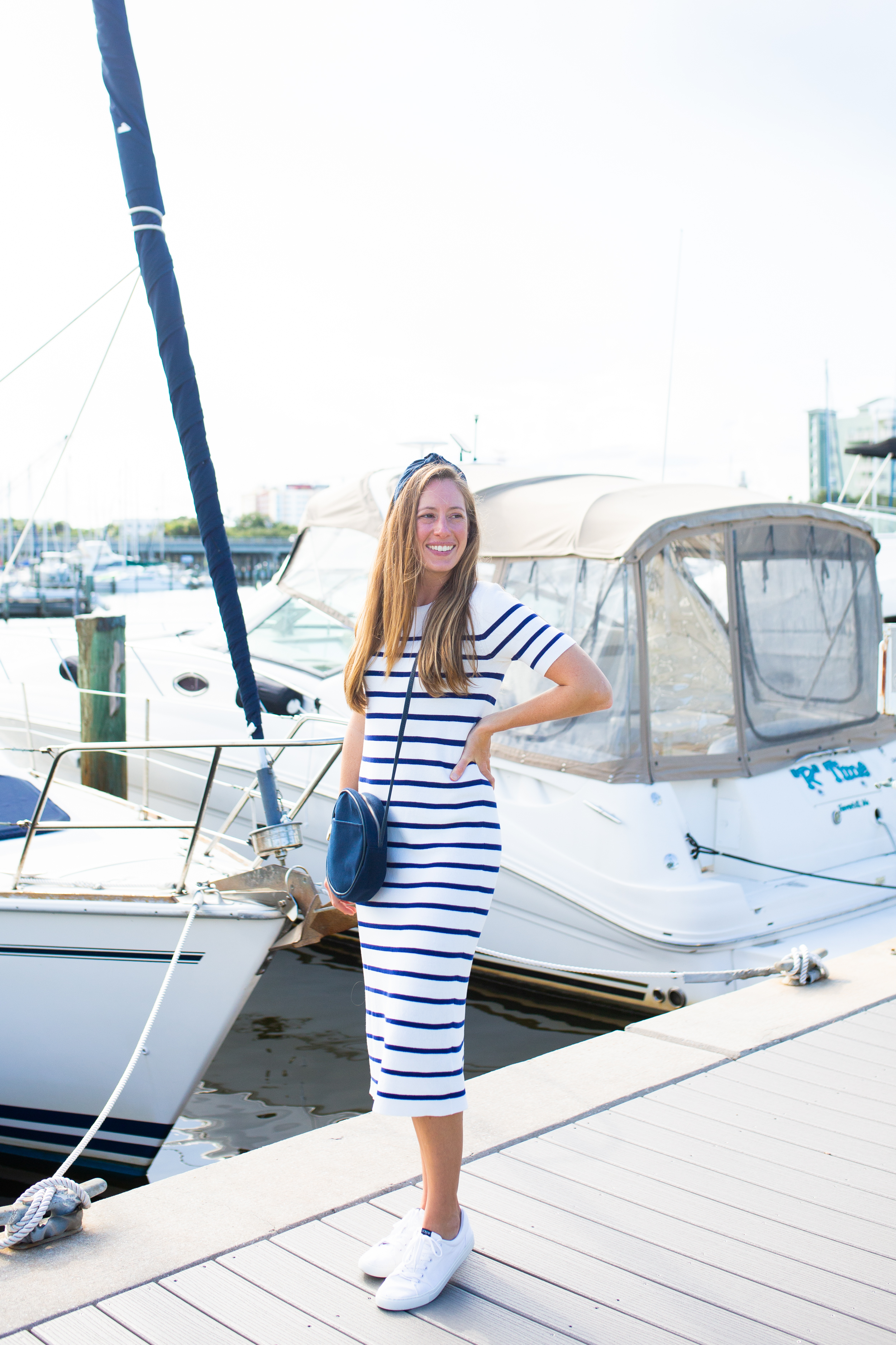 Transition from summer to fall with a sweater dress! A classic striped dress styled with sneakers, a hat and denim jacket is a perfect late summer outfit. Read the full post with dressing for fall in warm-weather! 