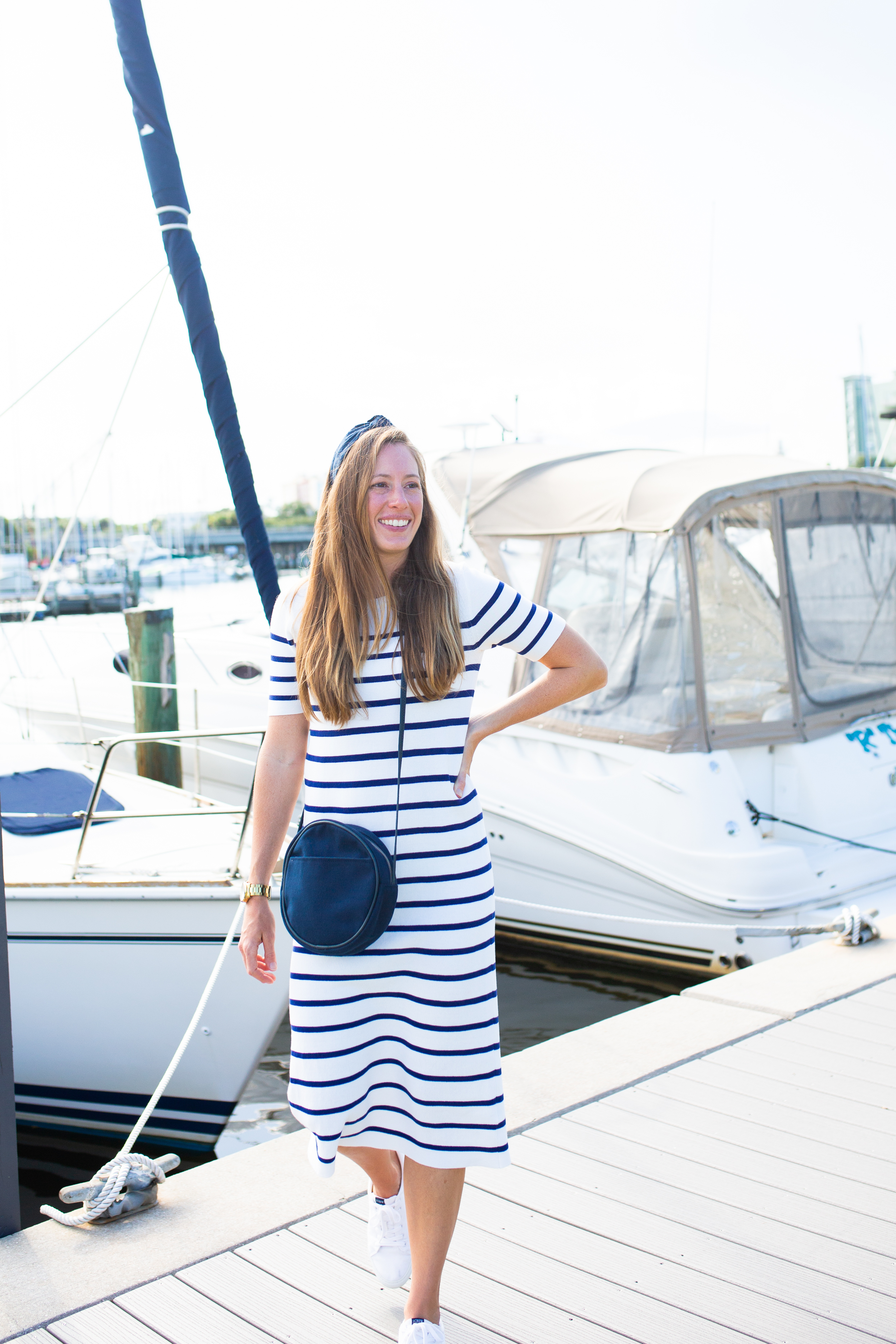 Transition from summer to fall with a sweater dress! A classic striped dress styled with sneakers, a hat and denim jacket is a perfect late summer outfit. Read the full post with dressing for fall in warm-weather! 