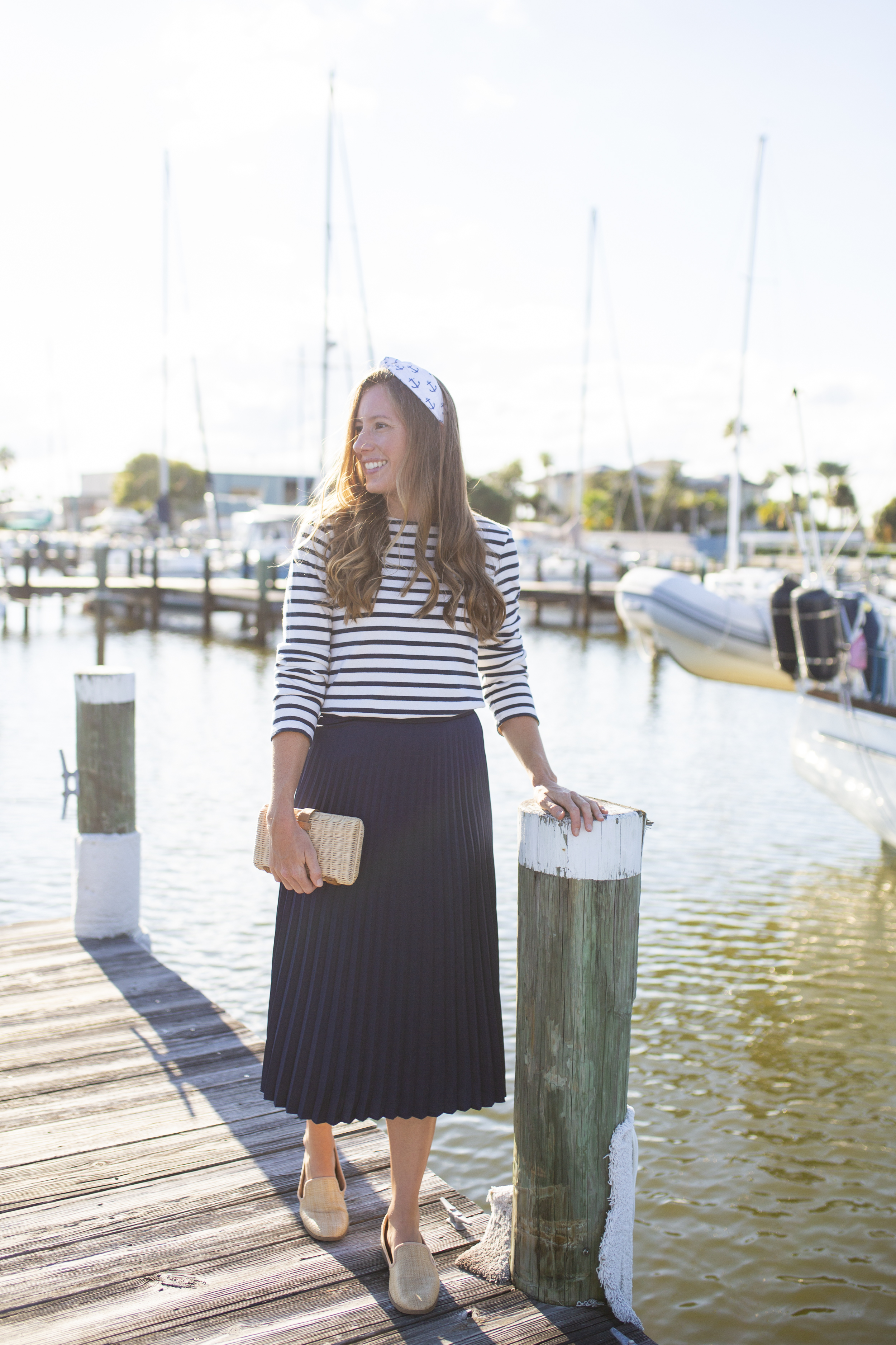 woman at the marina wearing stripe top, blue skirt, and Coastal Collection Headbands