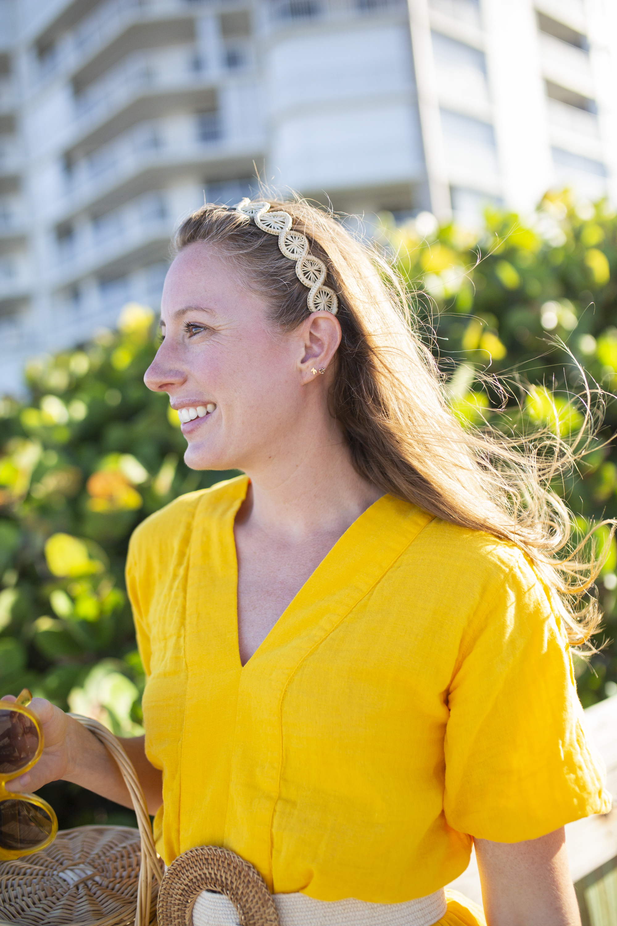 girl wears woven palm headband  with yellow caftan, espadrille wedges and basket bag at the beach