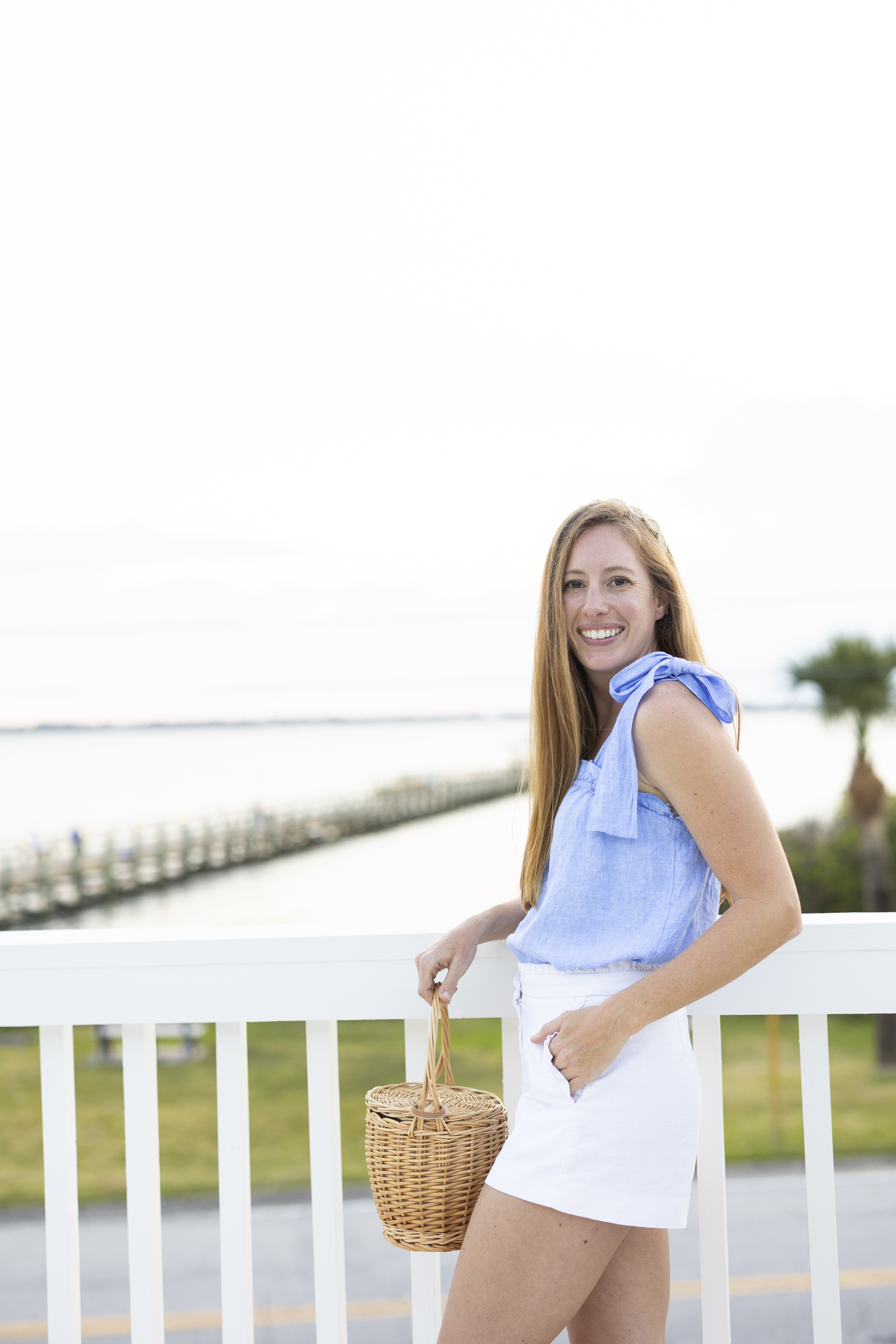 Coastal Grandma Summer Outfit / Girl wearing linen top and white shorts with an adjustable raffia headband in Florida 